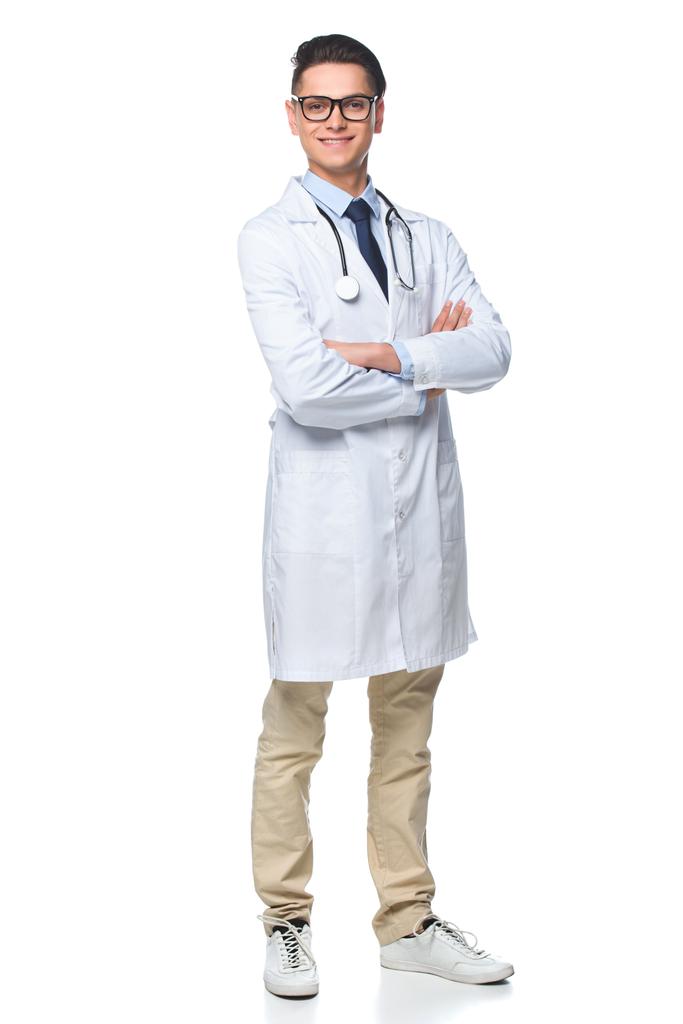 feliz joven médico con los brazos cruzados mirando a la cámara aislada en blanco
 - Foto, imagen