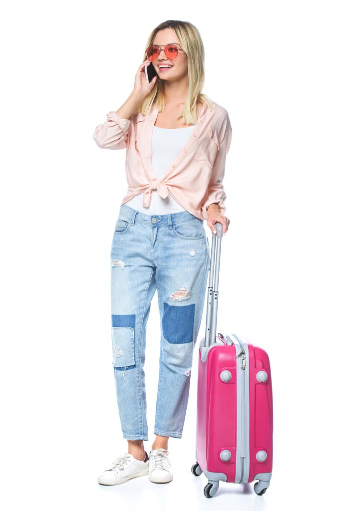 reizende jongedame met bagage praten via de telefoon geïsoleerd op wit - Foto, afbeelding