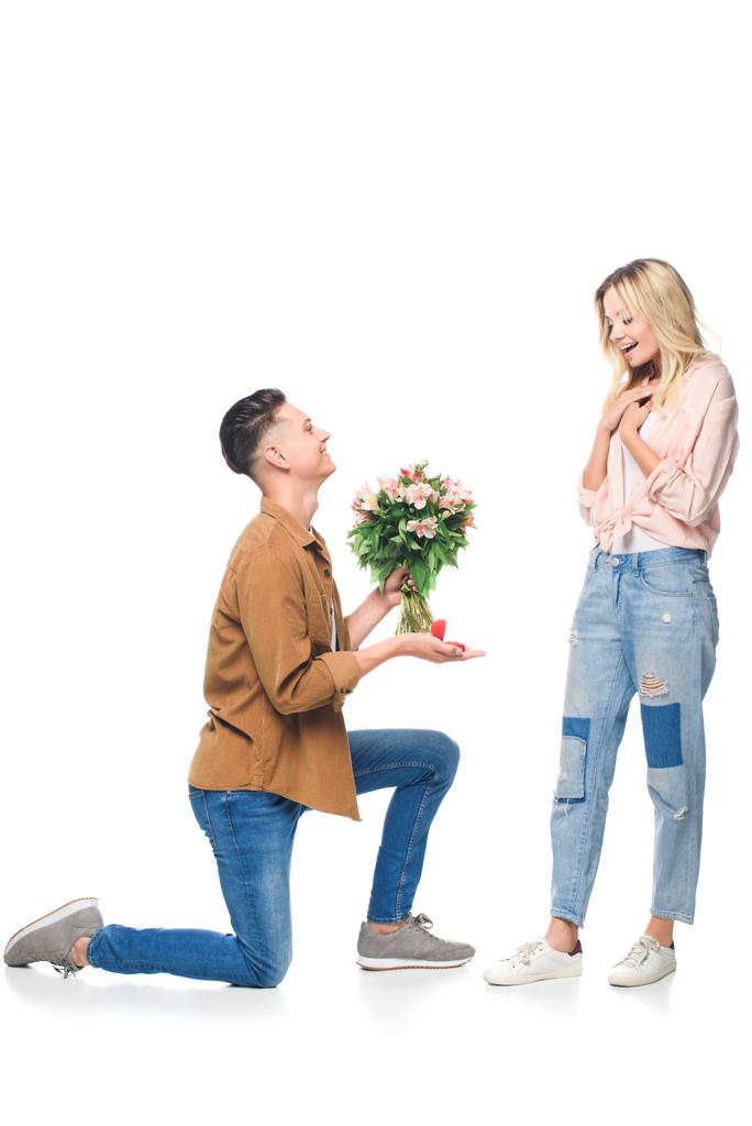 боковой вид счастливого молодого человека, делающего предложение подруге, изолированной на белом
 - Фото, изображение
