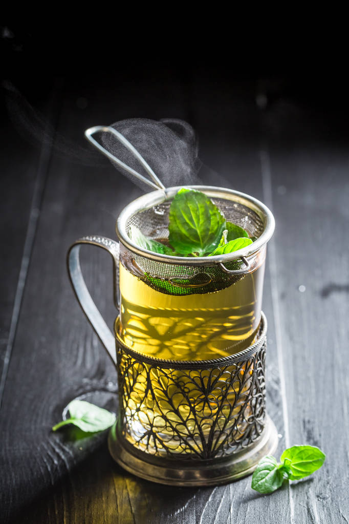 Brassage de thé vert frais et savoureux sur une vieille table noire
 - Photo, image
