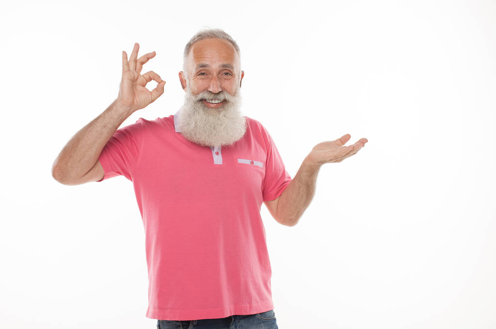 Feliz hombre barbudo mayor sonriente sosteniendo algo imaginario en la mano
. - Foto, Imagen