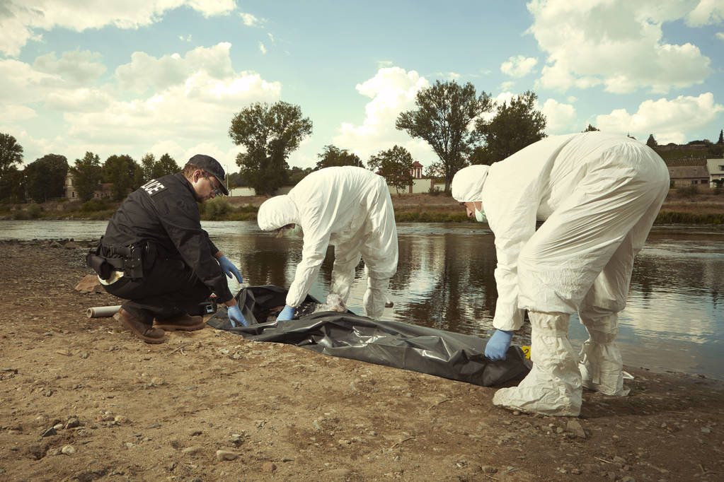 Kobiety znaleziono rzeką utonął na bank w mieście umieszczone w torbie ciała na transportration - Zdjęcie, obraz