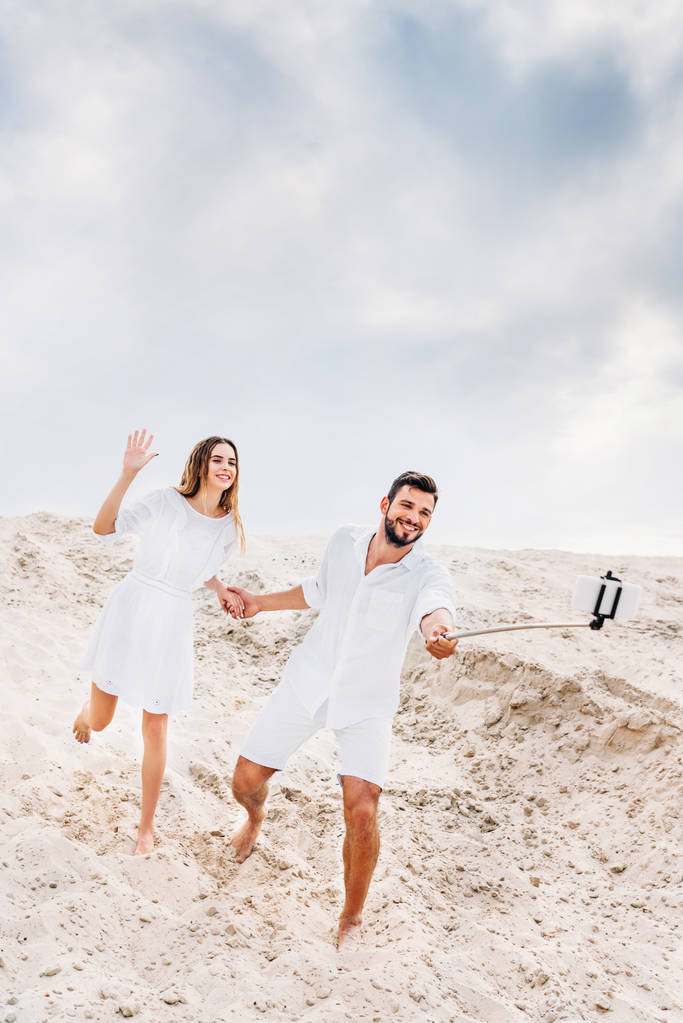 giocoso giovane coppia scattare selfie con monopiede e smartphone nel deserto
 - Foto, immagini