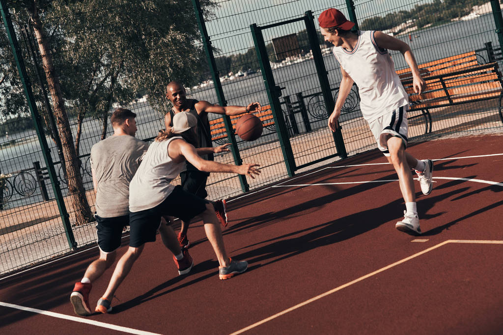 groupe de jeunes hommes en vêtements de sport jouant au basket en plein air
 - Photo, image