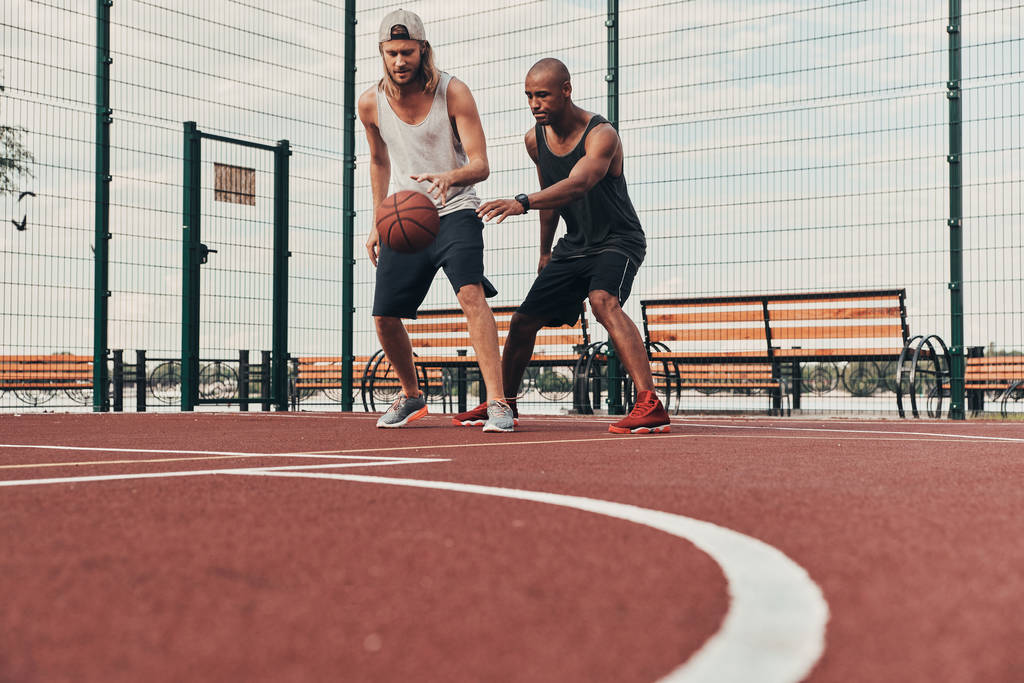 Twee jonge mannen spelen basketbal  - Foto, afbeelding