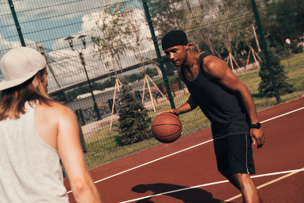 два спортсмена играют в баскетбол на улице на баскетбольной арене
 - Фото, изображение