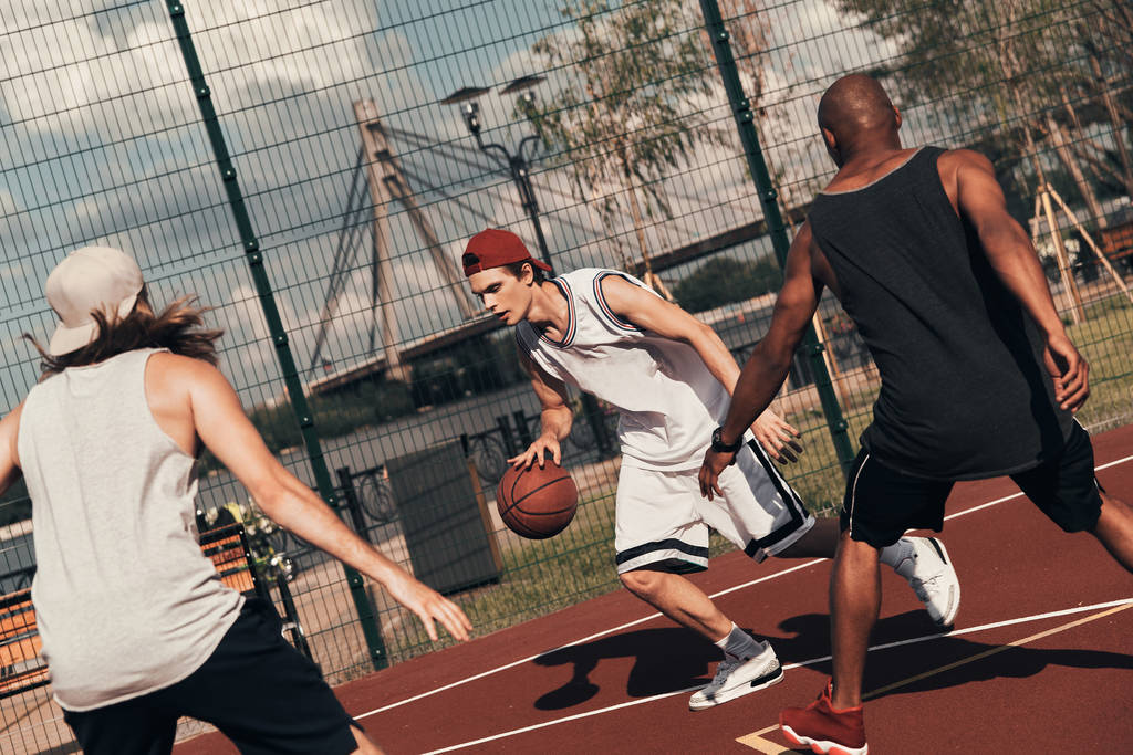 sportsmen playing basketball outdoors on basketball arena cage - Photo, Image