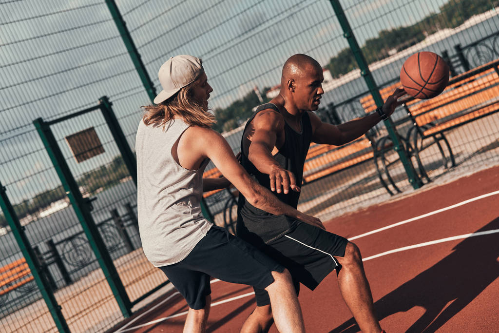 двое друзей играют в баскетбол на улице на баскетбольной арене
 - Фото, изображение