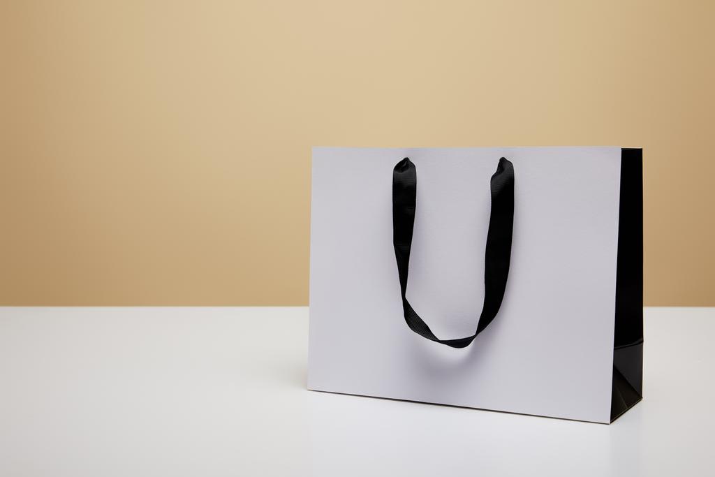 um saco de compras branco na mesa branca isolada em bege
 - Foto, Imagem