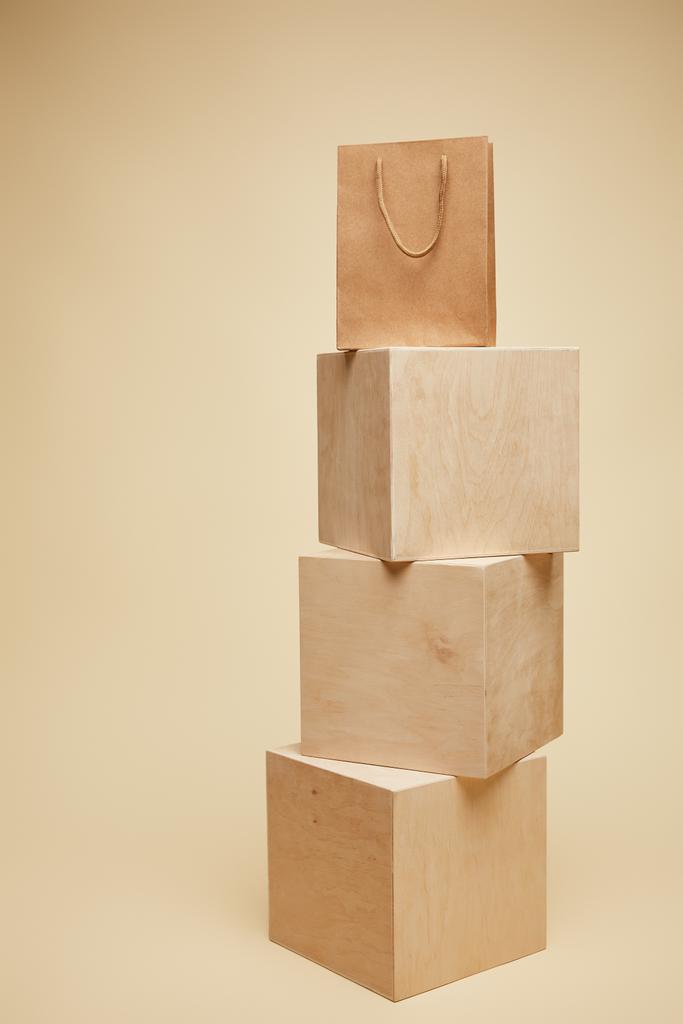 one shopping bag on wooden cubes isolated on beige  - Photo, Image