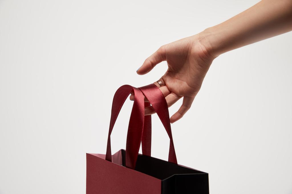 immagine ritagliata di donna in possesso di shopping bag rosso in mano isolato su bianco
  - Foto, immagini