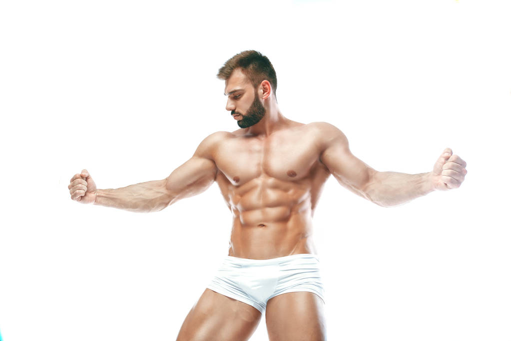Bodybuilder posiert. schöner sportlicher Kerl mit männlicher Power. Fitness muskulöser Mann in weißen Dessous. auf isoliertem weißem Hintergrund. - Foto, Bild