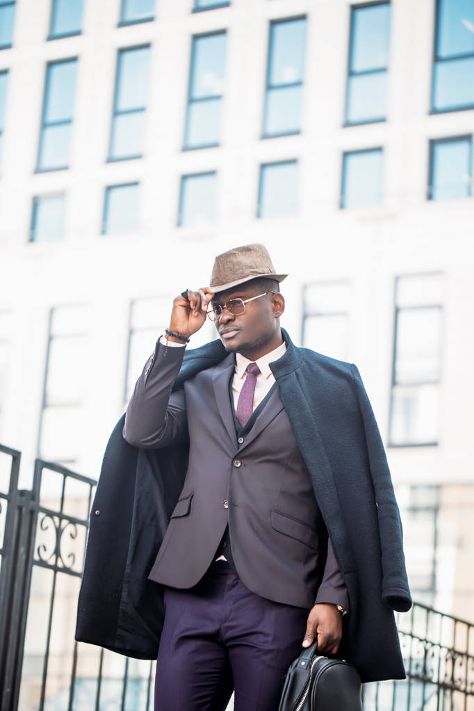 Красивый бизнесмен в модной одежде трогает шляпу
 - Фото, изображение