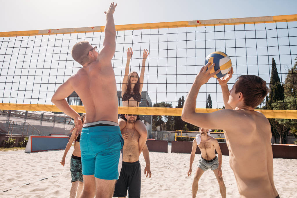 Group of resting playing volleyball on beach court - Photo, Image