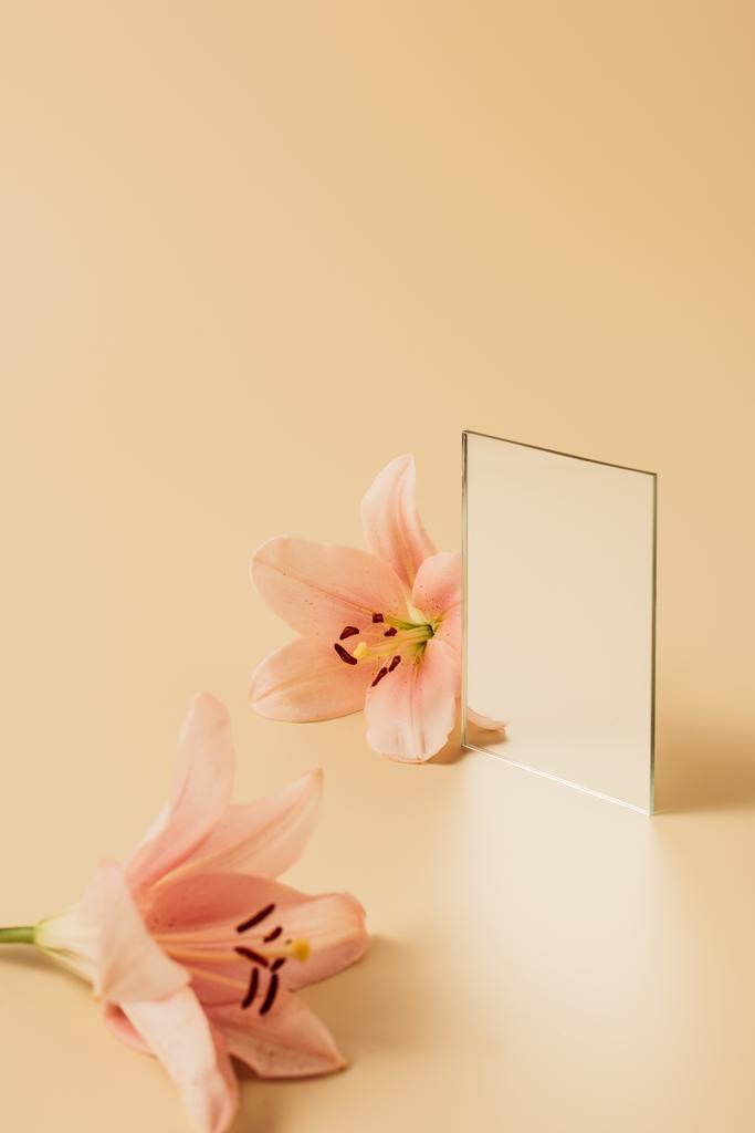 цветы лилии и зеркало на бежевом столе
 - Фото, изображение
