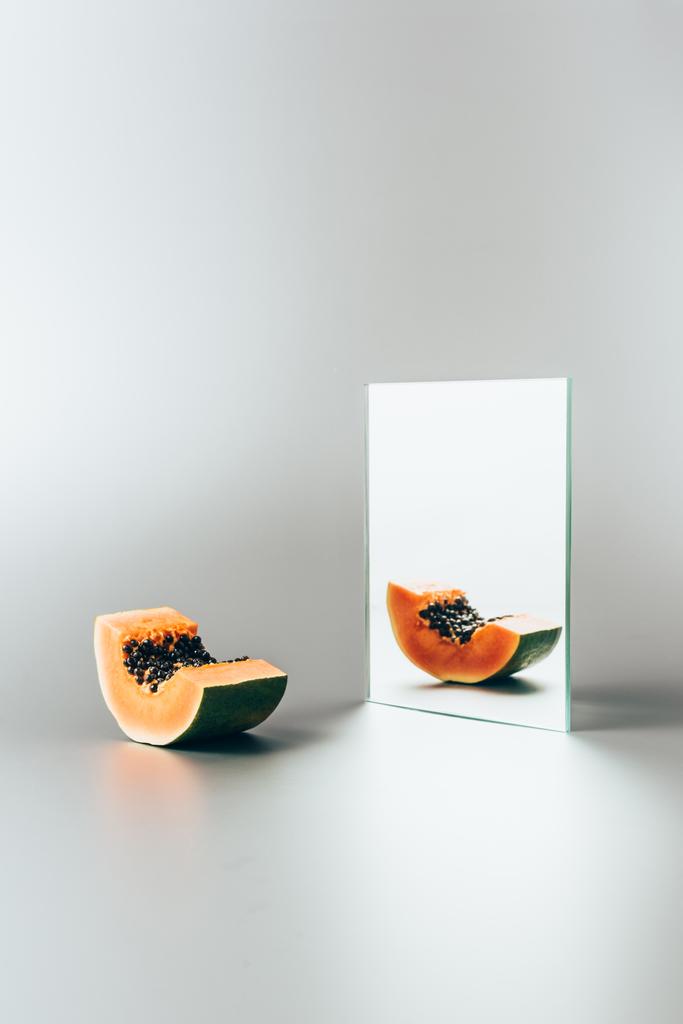 exotische Papaya spiegelt sich im Spiegel auf weißem Tisch  - Foto, Bild