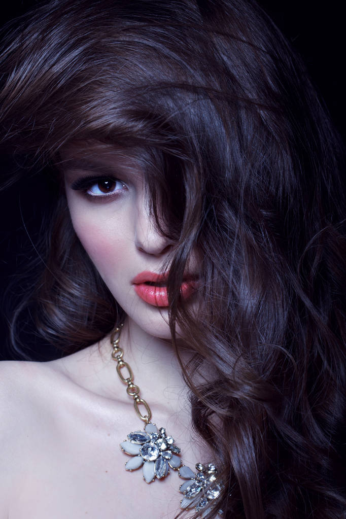 модный портрет чувственной брюнетки с вощеными волосами на черном студийном фоне, тонированный
 - Фото, изображение