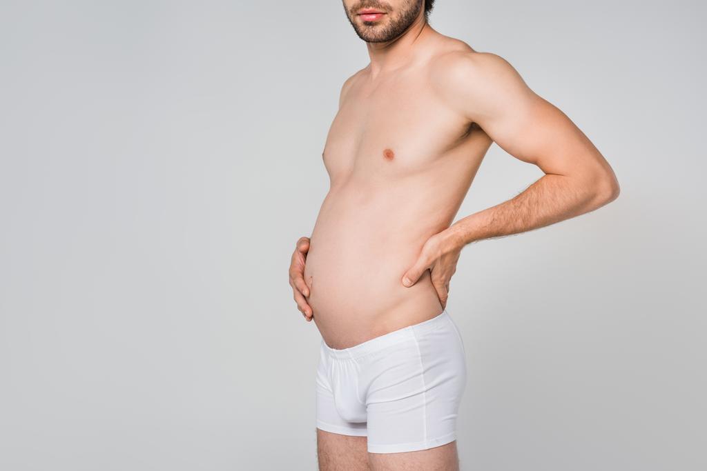 Μερική άποψη του ανθρώπου σε λευκό εσώρουχο με πρησμένο στομάχι που απομονώνονται σε γκρι - Φωτογραφία, εικόνα