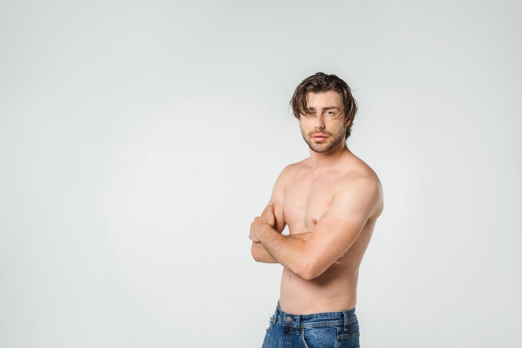 retrato de homem sem camisa pensivo em jeans olhando para câmera isolada em cinza
 - Foto, Imagem