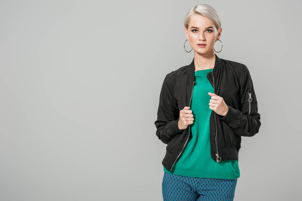 fashionable young female model in black jacket posing isolated on grey background  - Photo, Image