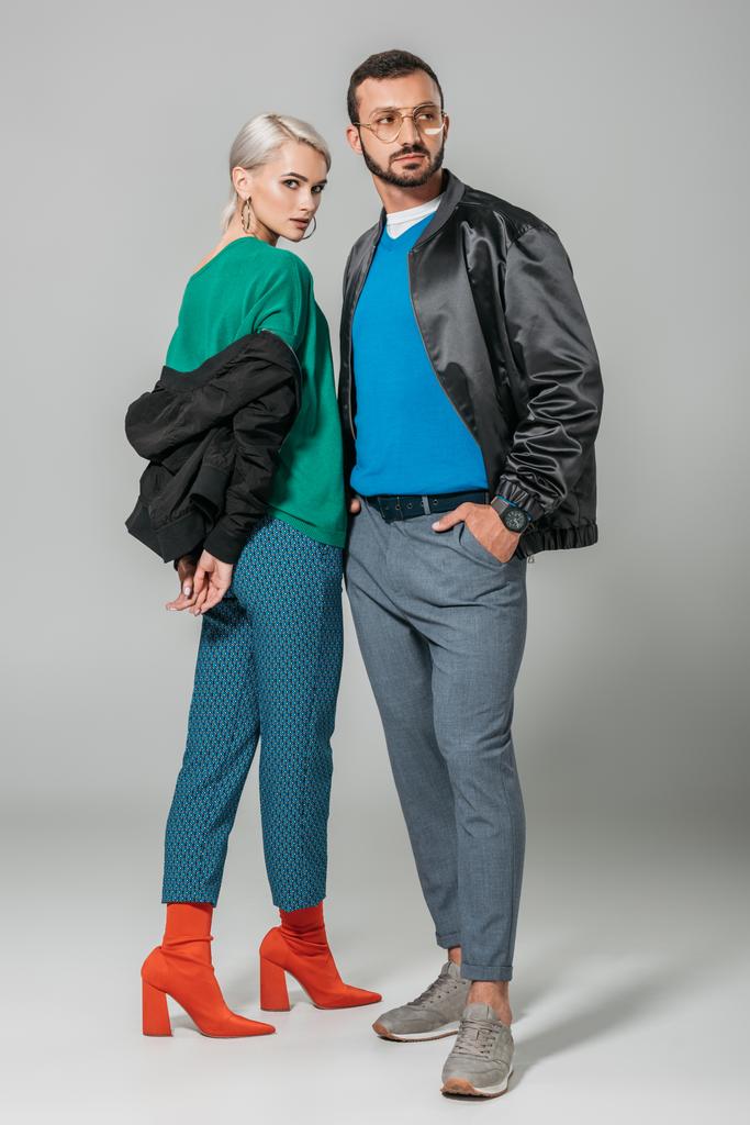 young couple of models in stylish autumn jackets on grey background  - Photo, Image