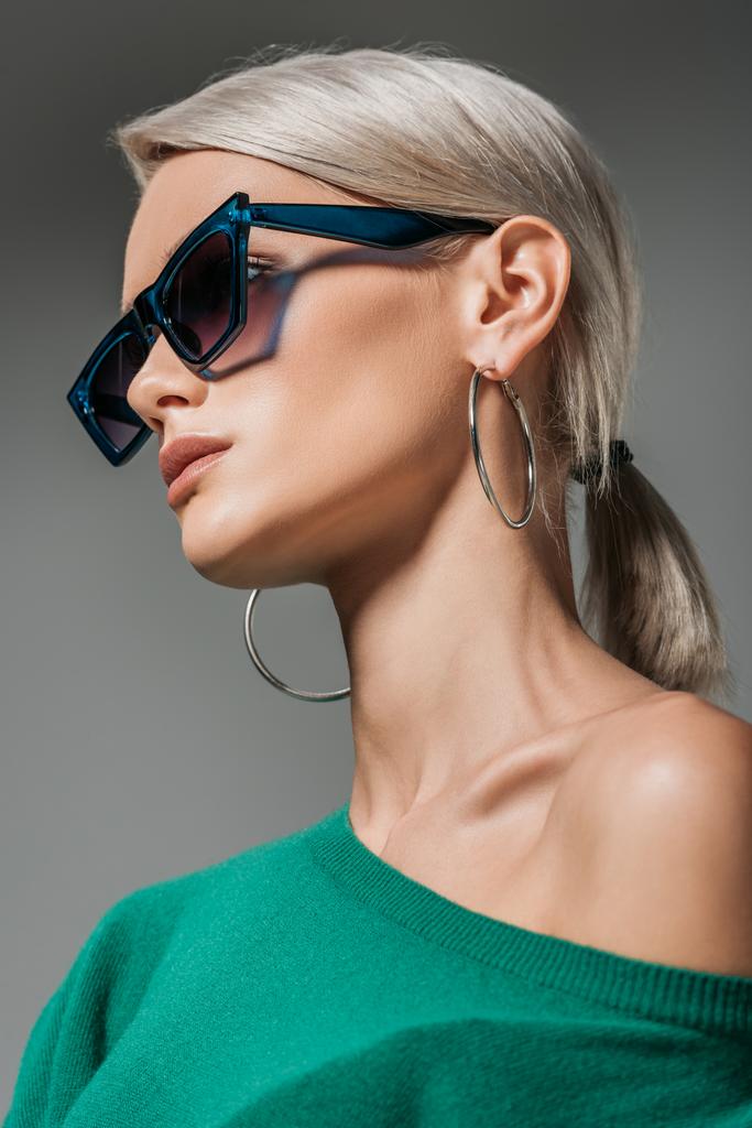 стильна жінка в сонцезахисних окулярах дивиться ізольовано на сірому фоні
  - Фото, зображення