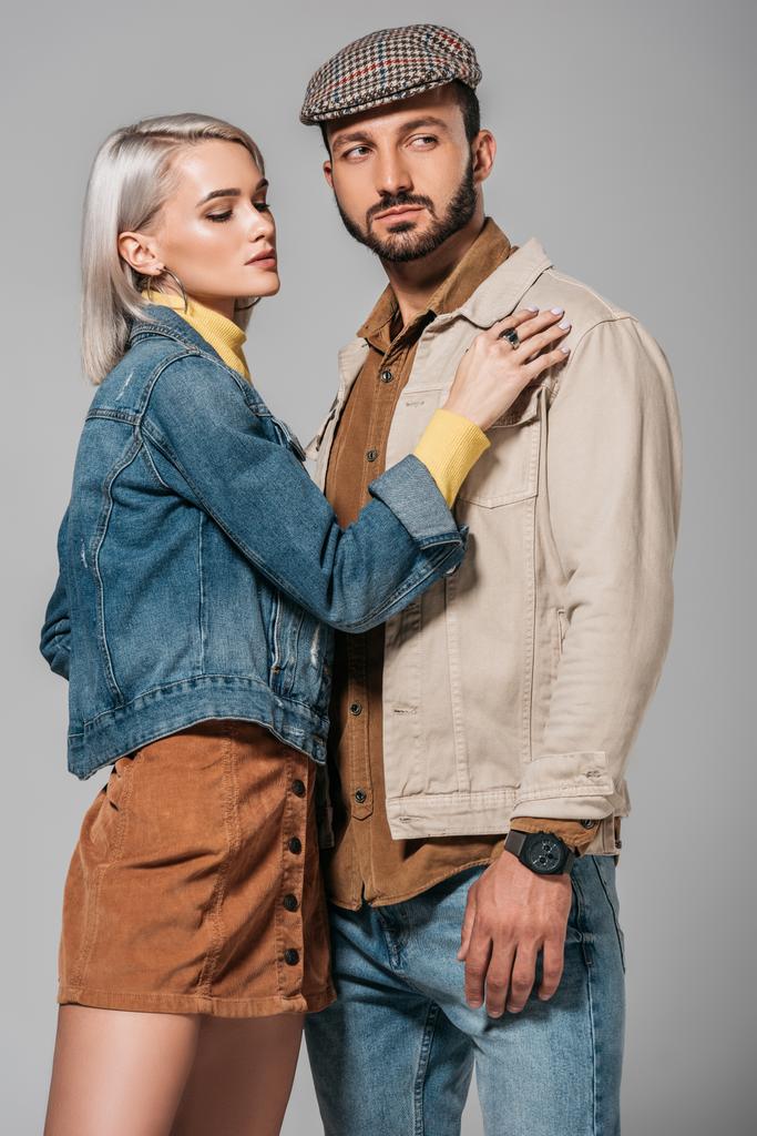 young couple posing in street style autumn outfit, isolated on grey - Photo, Image