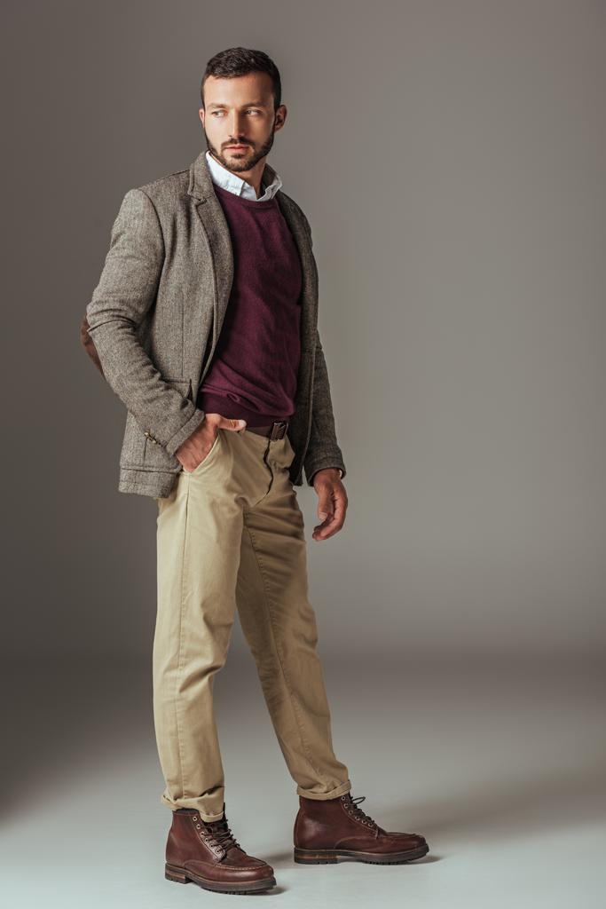 бородатый мужчина позирует в стильной осенней твидовой куртке, на сером
 - Фото, изображение