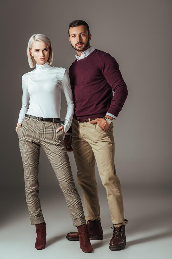молодая пара позирует в стильном осеннем наряде, на сером
 - Фото, изображение