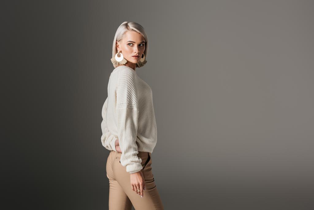 vonzó lány pózol fehér pulóvert, szürke elszigetelt - Fotó, kép