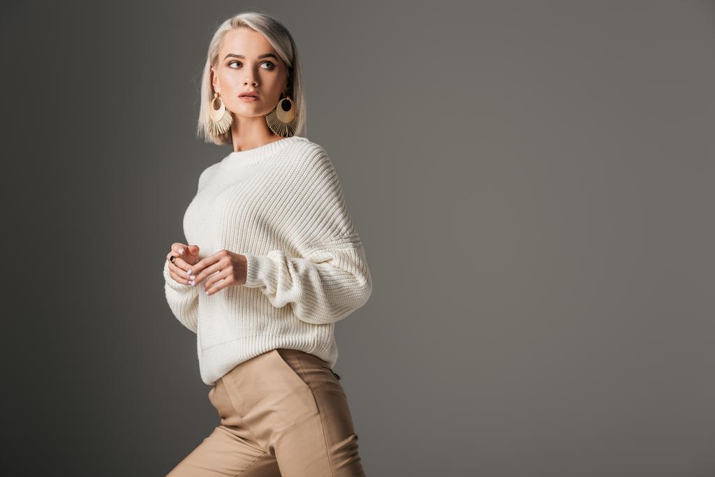 elegancki model blondynka pozowanie w biały sweter z dzianiny, na szarym tle - Zdjęcie, obraz