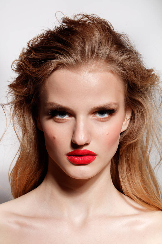 Portret van fotomodel met rode lippen en golvend kapsel - Foto, afbeelding