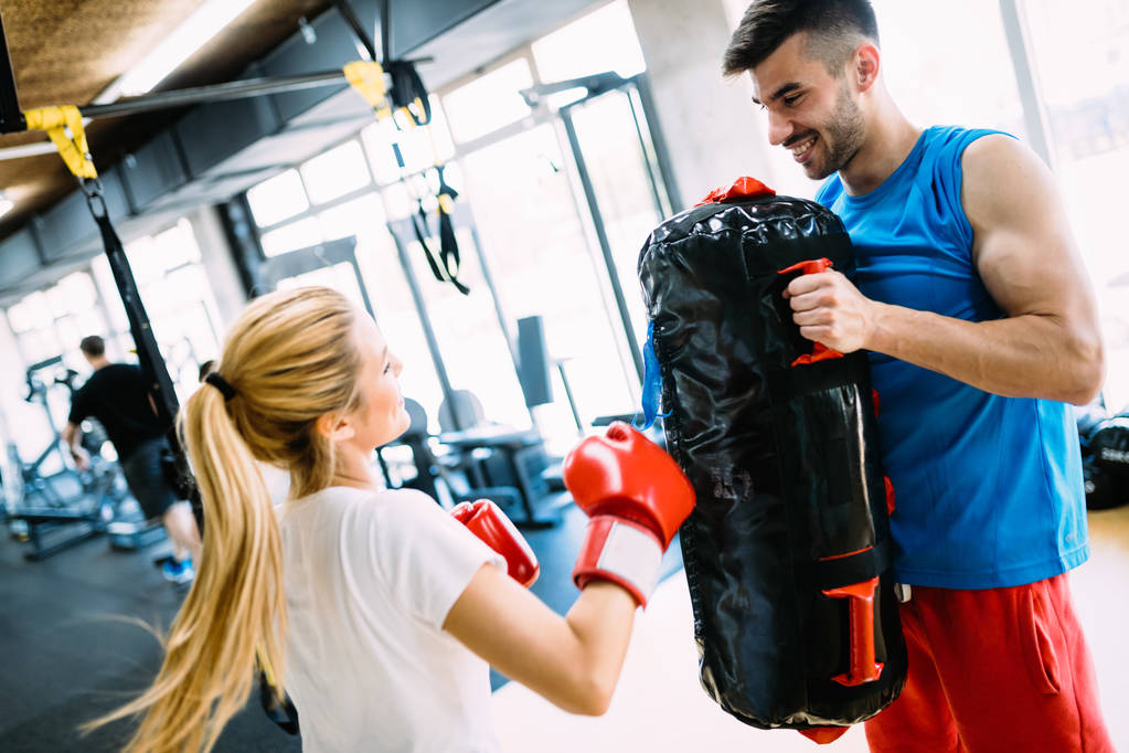 Boks trening Kobieta w fitness Klasa pierścień. Trener człowiek trzyma rękawiczki sportowe w siłowni - Zdjęcie, obraz