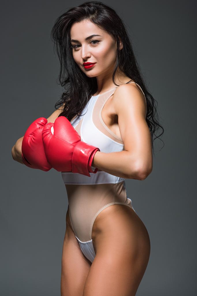 sexy donna atletica in body bianco e guanti da boxe isolati su grigio
 - Foto, immagini