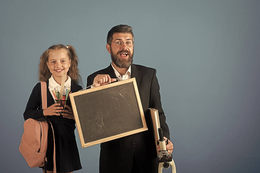 Dítě a otec drží mikroskop, tabule, knihy a papírnické zboží - Fotografie, Obrázek