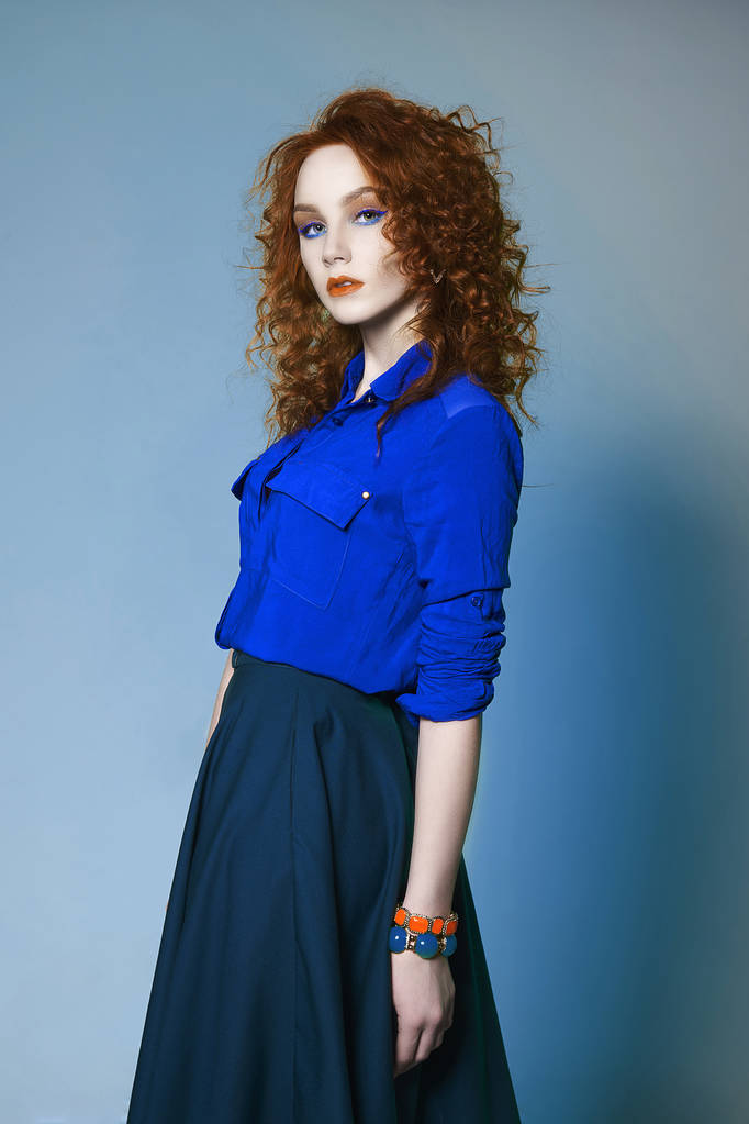κόκκινα μαλλιά ομορφιά νεαρή γυναίκα που θέτουν σε studio.beautiful τζίντζερ κορίτσι με χρώμα μακιγιάζ και σγουρά χτένισμα - Φωτογραφία, εικόνα