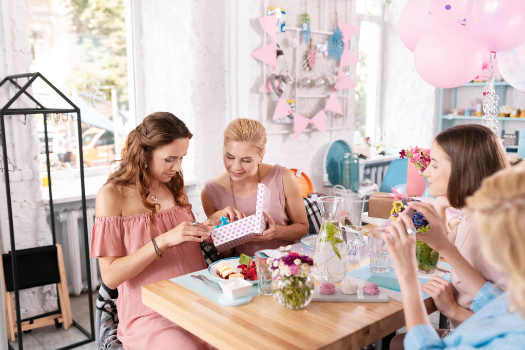Dark-haired zwangere vrouw viert haar verjaardag in café - Foto, afbeelding