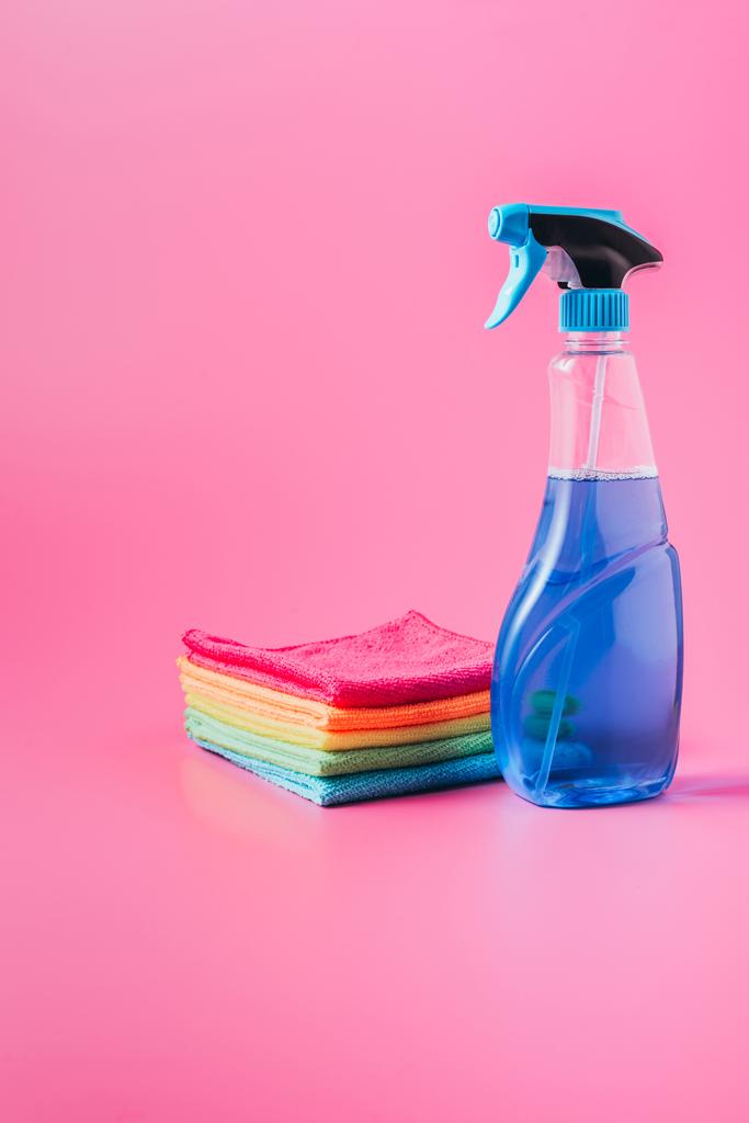close up view of cleaning fluid and stack of colorful rags, pink background  - Photo, Image