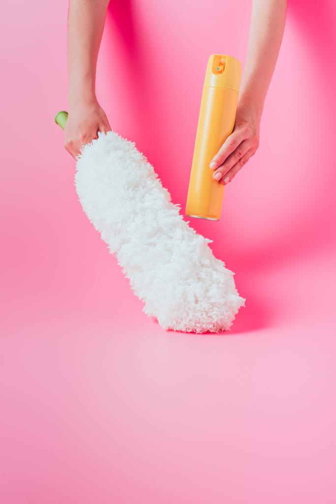 rajattu kuva naisten puhtaampaa holding spray purkki ja valkoinen pölynimuri, vaaleanpunainen tausta
  - Valokuva, kuva