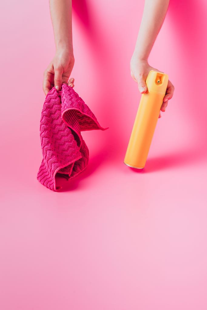 обрізане зображення жінки, що тримає розпилювач і ганчірку, рожевий фон
  - Фото, зображення