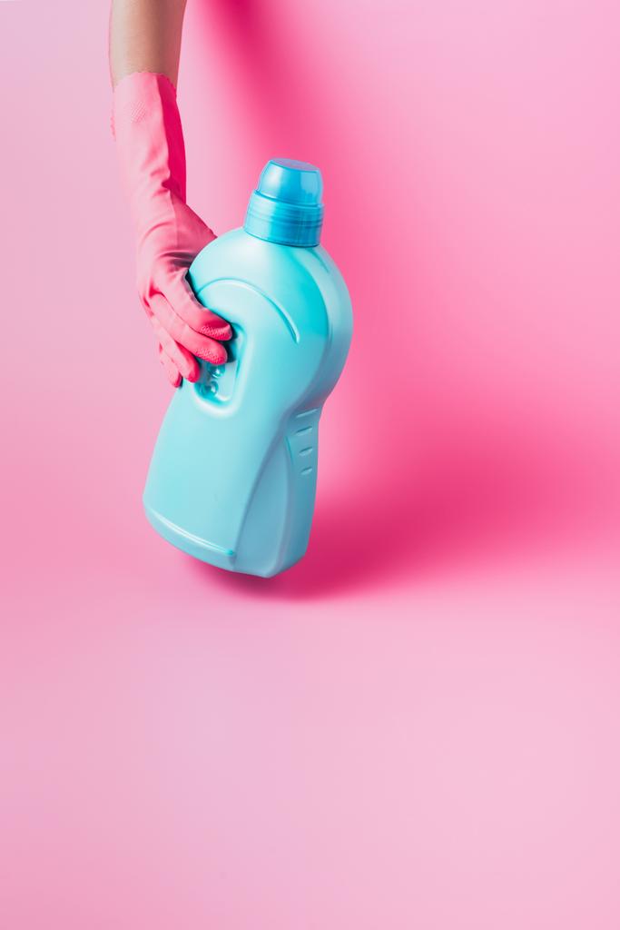 imagen recortada de la mujer en guante de goma que sostiene el líquido de la ropa, fondo rosa
 - Foto, imagen