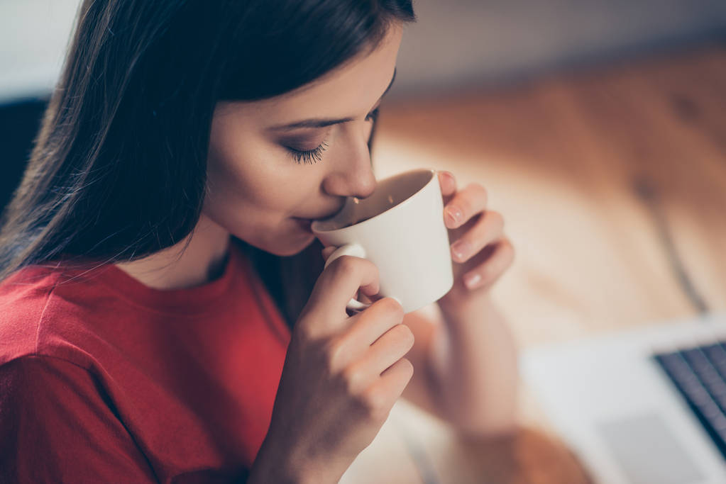 Crop photo of a girl who enjoys delicious aroma coffee with from a white mug sitting in a cafe - Photo, Image
