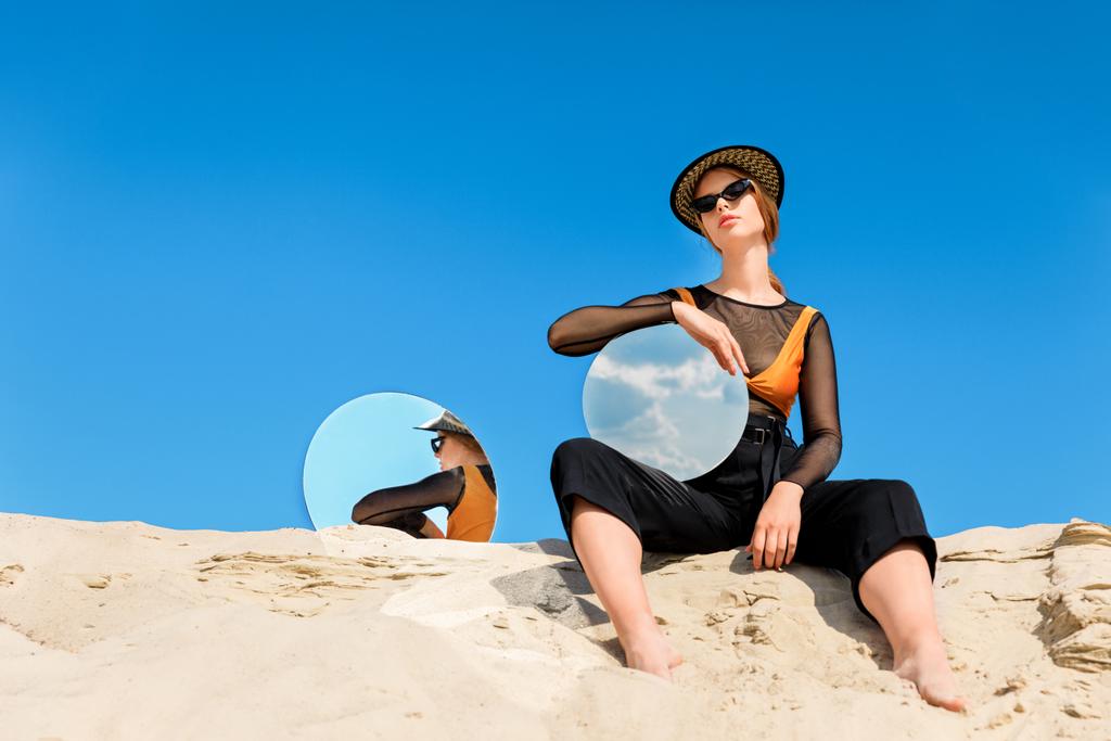 stylowy model pozowanie z lustra okrągłe z odbiciem błękitne niebo - Zdjęcie, obraz