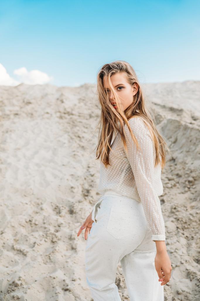 gyönyörű szőke lány pózol homok sivatagban fehér ruhát - Fotó, kép