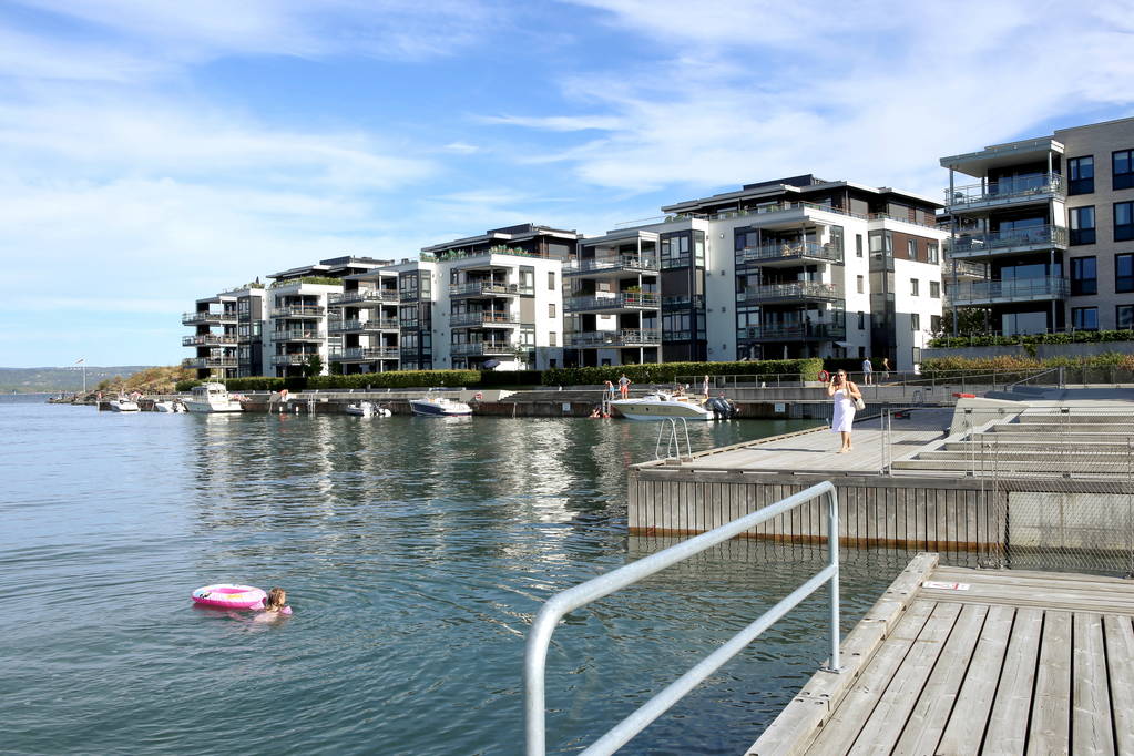 Oslo, Noorwegen - 23 juli 2018: Appartement gebouwen op de fjord van Oslo Fornebu district. Luxeappartementen met terrassen voor zonnebaden en zwemmen in de buurt van de Oceaan. - Foto, afbeelding