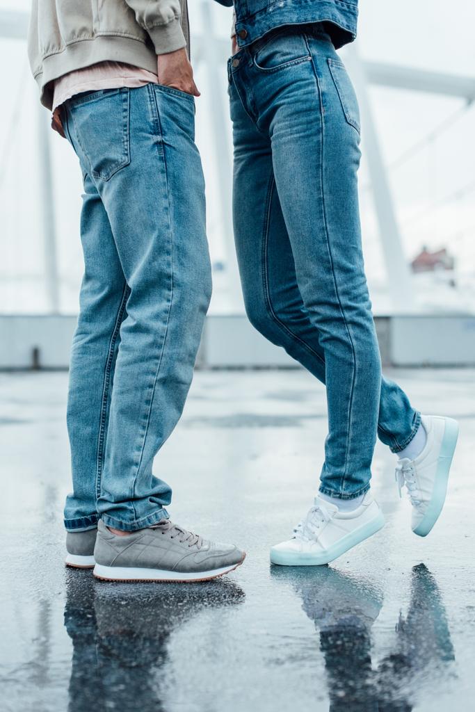 plan recadré de jeune couple en jeans et baskets flirtant sur le parking
 - Photo, image