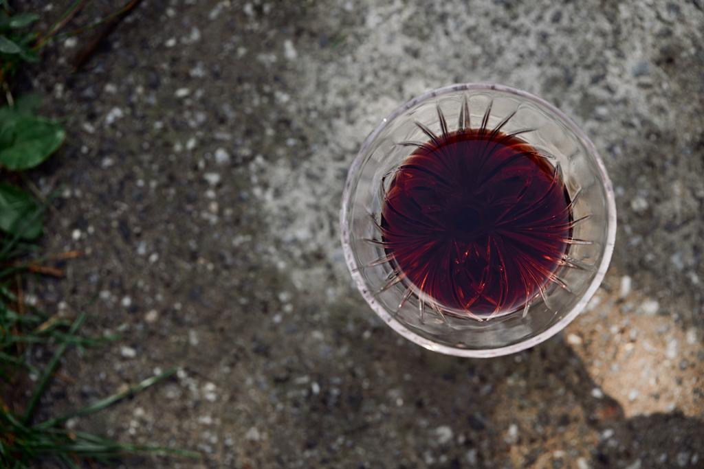 вид сверху на один бокал красного вина на дороге в саду
 - Фото, изображение