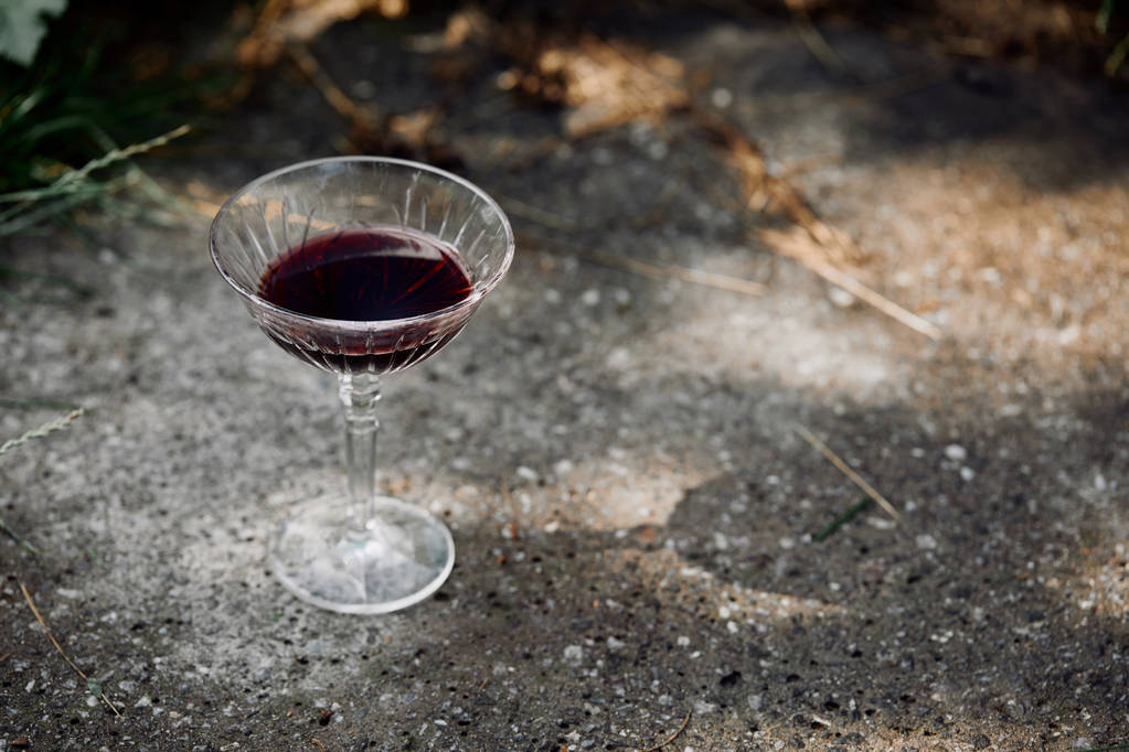 egy pohár vörös bor, aszfaltozott út, kert - Fotó, kép