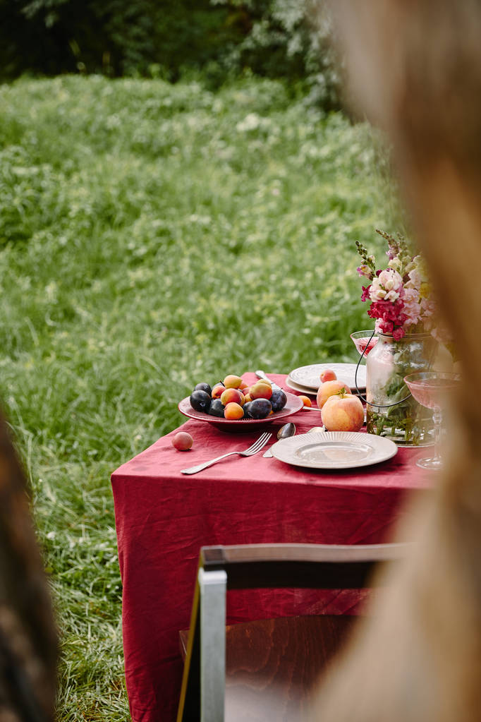 花と庭のテーブルで熟した果実のブーケ - 写真・画像