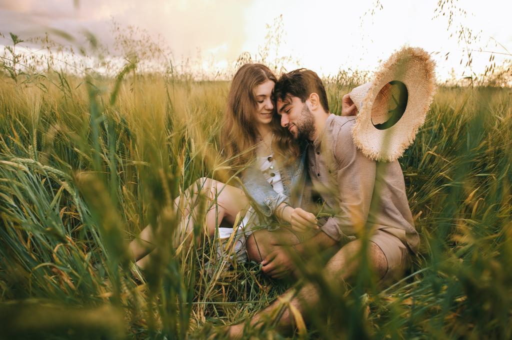 beautiful stylish couple hugging in green grass on meadow - Photo, Image